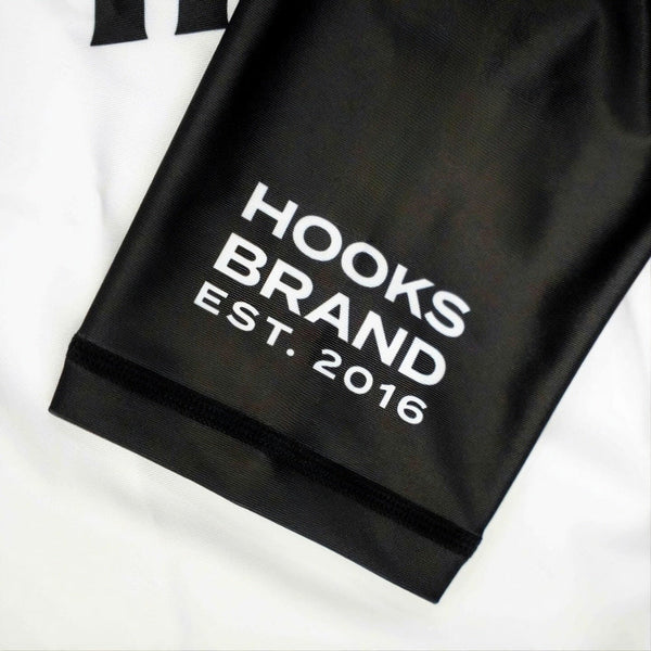 Hooks Kids 2026 Ranked BJJ Rash Guard White, close-up of black sleeve cuff showing "Hooks Brand Est. 2016" print