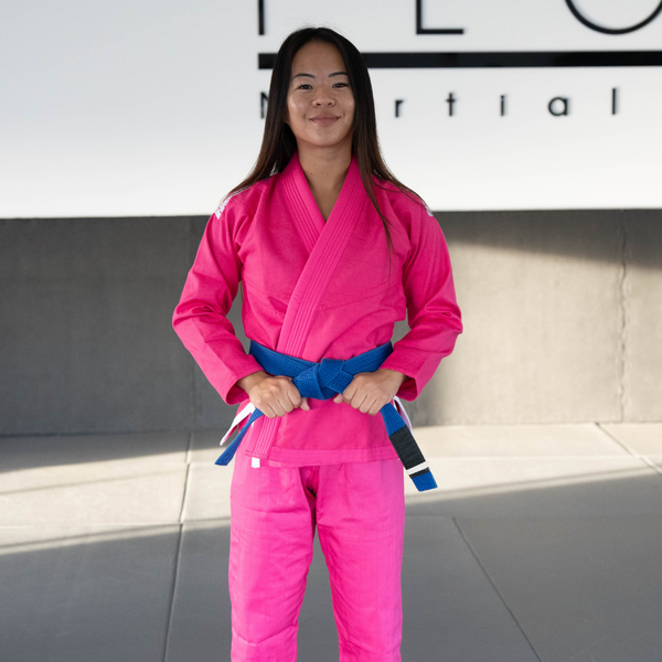 Hooks Pastel BJJ Gi in pink, front view worn by a person with a blue belt tied at the waist