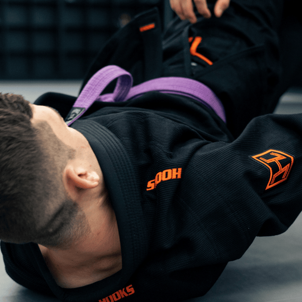 Hooks BJJ Gi Limited Edition Prolight Inferno, worn during live rolling, showing orange embroidered logos on sleeve