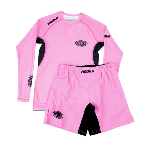 Hooks Rose Fusion Shorts, front flat lay paired with matching pink long-sleeve rash guard, black panel accents and oval logo