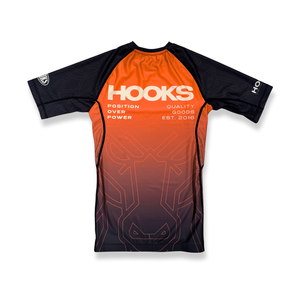 Hooks Short Sleeve Rash Guard - Fire Horse, front flat lay showing orange-to-dark gradient body with black sleeves