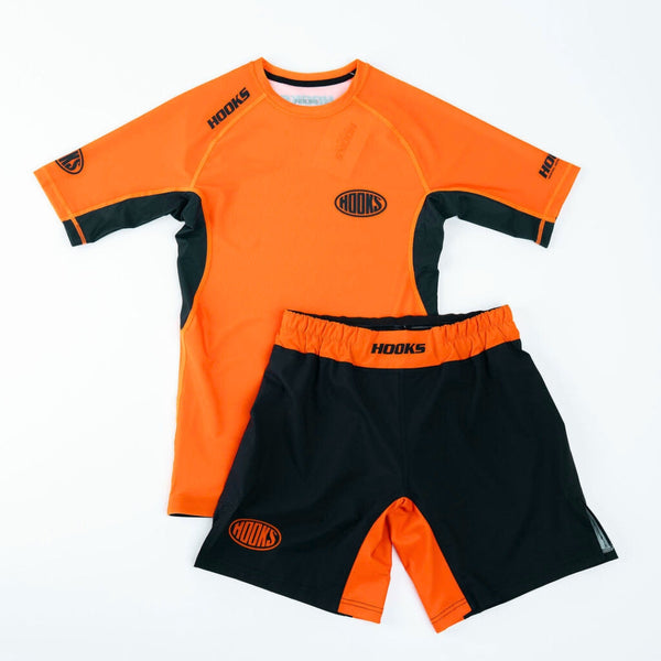 Hooks Fusion Shorts Inferno, front flat lay paired with matching orange and black short-sleeve rash guard