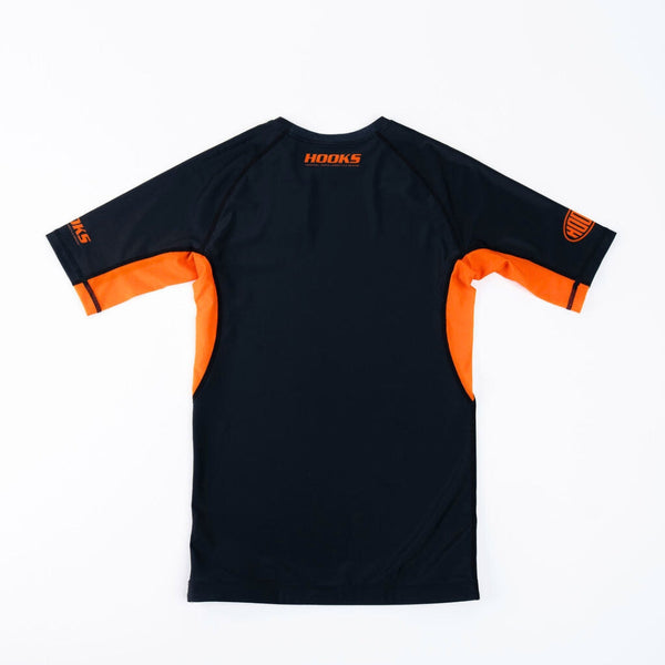 Hooks Short Sleeve Rash Guard Black Inferno, back view flat lay showing black body with orange side panels and sleeve