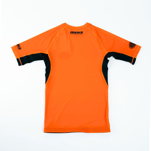Hooks Inferno Short Sleeve Rash Guard, back flat lay showing orange body with black side panels and sleeve inserts