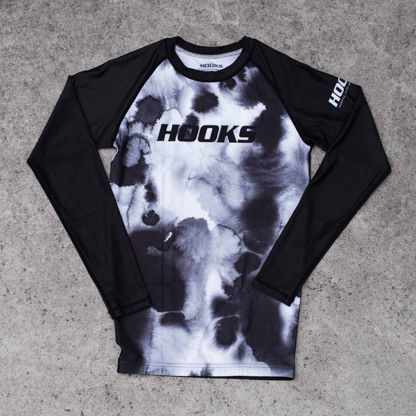 Hooks BJJ Long Sleeve Rash Guard Black Mist, front flat lay showing ink-wash black and white body with solid black raglan
