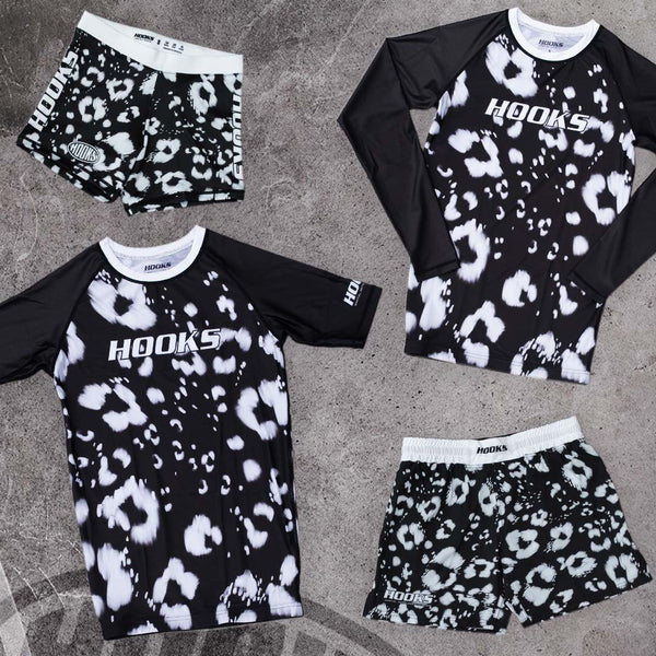 Hooks Prowl collection flat lay showing short sleeve and long sleeve rash guards alongside compression shorts and MMA shorts