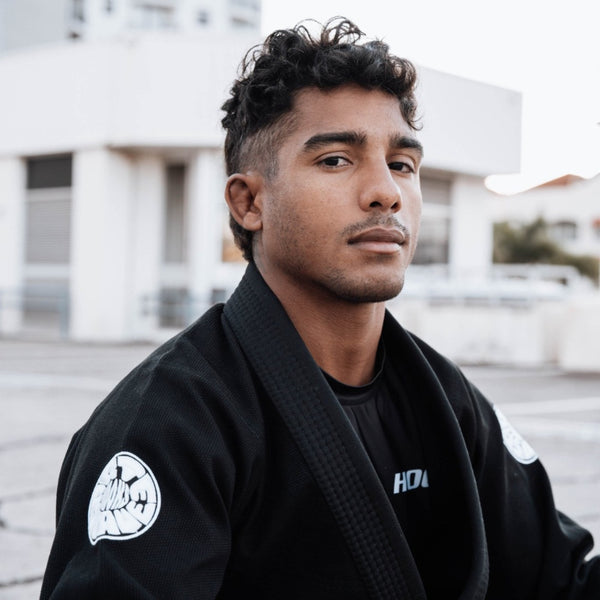 Black martial arts gi with white Arte Suave Hooks emblems, suitable for Brazilian Jiu-Jitsu training and competition.