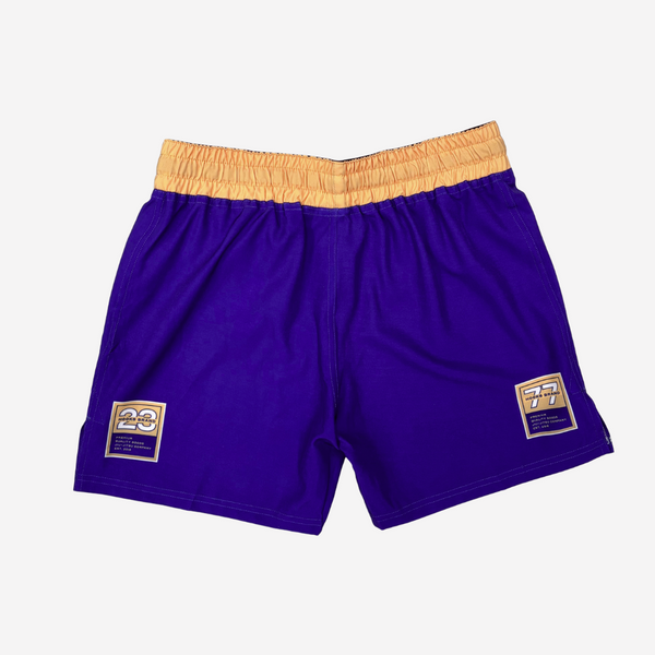 Purple shorts with gold waistband and accents on a white background