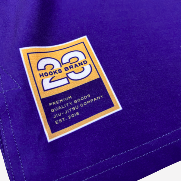 Close-up of a purple fabric with a '23 Hooks Brand' logo and text.