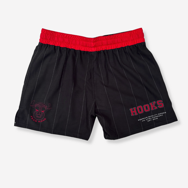 Black pinstripe shorts with red waistband and text on a light gray background