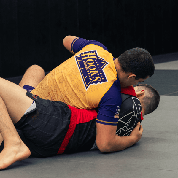Athlete grappling while wearing the yellow Showtime rashguard.